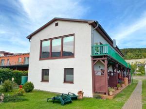 Dieses weiße Haus verfügt über eine Veranda und einen Balkon. in der Unterkunft Ferienwohnungen Stadtmitte - Fewo 1 in Sassnitz