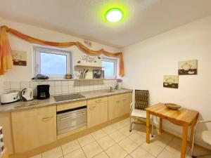 eine Küche mit einem Waschbecken und einem Tisch darin in der Unterkunft Ferienwohnungen Stadtmitte - Fewo 1 in Sassnitz