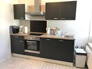een keuken met een fornuis en een spoelbak bij Haus Stothfang - Ferienwohnung 3 in Sassnitz