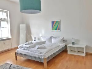 a bedroom with a bed with white sheets and a lamp at Haus Stothfang - Ferienwohnung 3 in Sassnitz