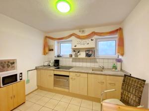 eine Küche mit Spüle und Mikrowelle in der Unterkunft Ferienwohnungen Stadtmitte - Fewo 1 in Sassnitz + 9 Fotos