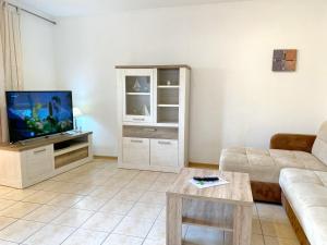 ein Wohnzimmer mit Couch und Fernseher in der Unterkunft Ferienwohnungen Stadtmitte - Fewo 1 in Sassnitz