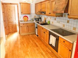 a kitchen with wooden cabinets and a wooden floor at Wohnung 3 in Burghaslach