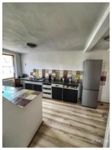 a large kitchen with stainless steel appliances and wooden floors at Wohnung 4 in Burghaslach