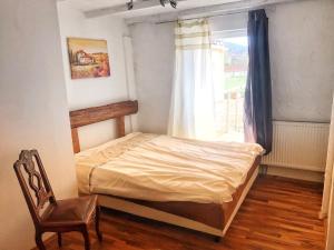 a bedroom with a bed and a chair and a window at Wohnung 6 und 7 in Burghaslach