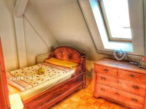 um pequeno quarto com uma cama de madeira e uma cómoda em Wohnung 2 em Burghaslach