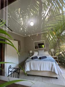a bedroom with a bed and a palm leaf ceiling at Occi Lodge in Sodwana Bay