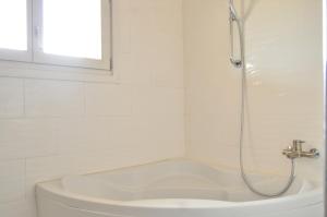 a white bathroom with a shower and a tub at Ranch Tanit Djerba in Midoun