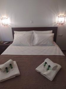 um quarto com uma cama com toalhas em Enigma Boutique Houses Ammos em Marmari