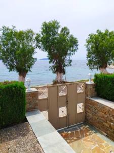 a gate with trees and the ocean in the background at Enigma Boutique Houses Ammos in Marmarion