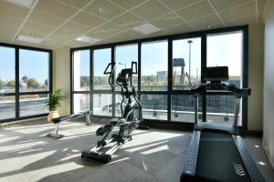 a gym with a large room with a large window at Golden Tulip Reims Bezannes in Reims