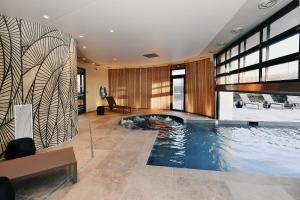 a large swimming pool in a house at Golden Tulip Reims Bezannes in Reims