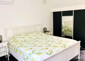 a bedroom with a white bed with a floral bedspread at Villa de 4 chambres avec piscine privee sauna et jardin clos a Villemeux sur Eure in Villemeux-sur-Eure