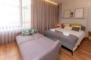 a bedroom with two beds and a couch in it at Charming Central Studio with AC in Porto