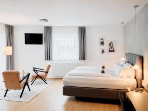 1 dormitorio con cama, escritorio y silla en ARX Guesthouse, en Schladming