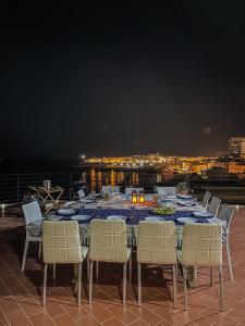 a dining table and chairs on a balcony at night at Salento Palace Bed & Breakfast in Gallipoli