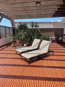 two white couches sitting on a deck with plants at Salento Palace Bed & Breakfast in Gallipoli