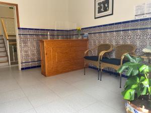 a room with two chairs and a wooden door at Apartamentos Martell in Playa de Santiago