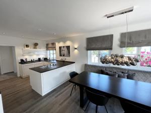 uma cozinha e sala de jantar com uma mesa preta em Lake Style Studios em Rottau