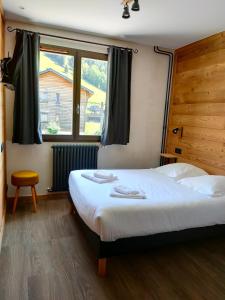 Un dormitorio con una cama grande y una ventana en Hôtel le Christiania, en Arêches