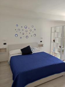 1 dormitorio con 1 cama azul y reloj en la pared en CASE DI BACCO, en Agropoli