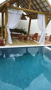a swimming pool with a gazebo and a swimming pool at Pousada Lírio Trancoso in Trancoso