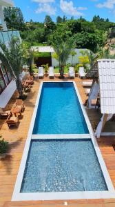 a swimming pool in a resort with lounge chairs at Pousada Lírio Trancoso in Trancoso