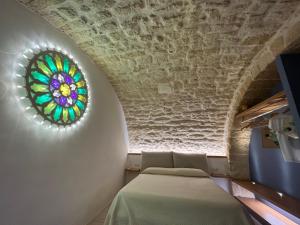 Zimmer mit einem Bett und einem Buntglasfenster in der Unterkunft Pietrabianca Santa Maria Apartments in Manfredonia