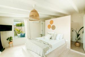 ein weißes Schlafzimmer mit einem Bett und einem Fenster in der Unterkunft Views Apartments & Suites in Parga
