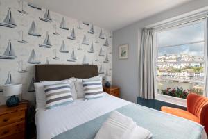 a bedroom with a bed and a window with sails on the wall at Harbour View in Brixham