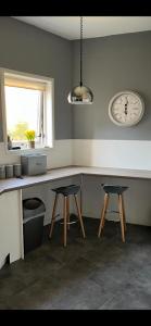 a kitchen with two stools and a counter with a clock at Riverside in Musselburgh