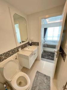 y baño con aseo, lavabo y espejo. en ELEGANT 1 Bedroom in Orient Resort & Spa en Jomtien Beach