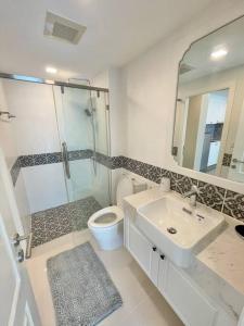a bathroom with a sink and a toilet and a mirror at ELEGANT 1 Bedroom in Orient Resort & Spa in Jomtien Beach