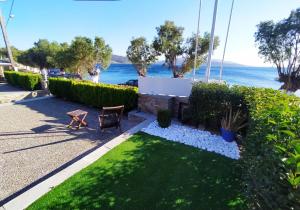 a garden with a bench and the ocean in the background at Enigma Boutique Houses Votsalo in Marmarion