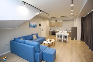 a living room with a blue couch and a table at Sunny Hill Residence in Vlorë