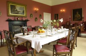 a dining room with a long white table and chairs at Ballyduff House in Thomastown