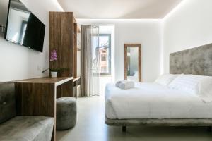 a bedroom with a bed and a tv and a couch at DOMUS CAVOUR Rooms&Suites in Tirano