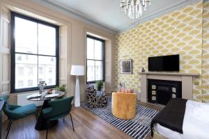 a bedroom with a bed and a fireplace and a tv at 30 Castle Street Deluxe Apartments in Edinburgh