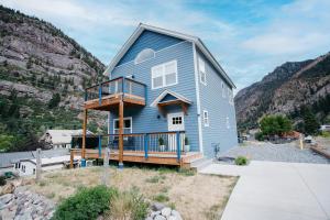 a blue house with a balcony on a hill at 230 9th Avenue in Ouray