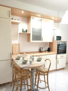 una cucina con tavolo, sedie e frigorifero di Victory house a Lido di Ostia