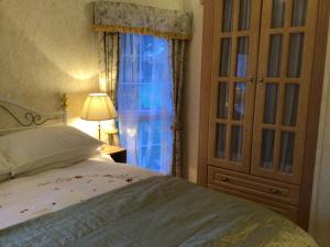 um quarto com uma cama, uma cómoda e uma janela em Beautiful 2-Bed holiday home nr Kynance cove em Helston