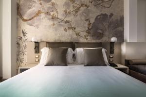 ein Schlafzimmer mit einem großen Bett und einem Gemälde an der Wand in der Unterkunft Life Hotel in Bibione