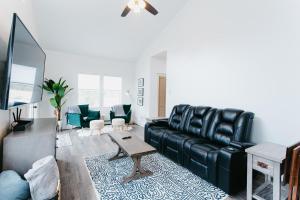 a living room with a black leather couch and a table at Big Blue Basecamp in Ouray CO in Ouray