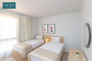 a hotel room with two beds and a table at Prime Holidays Caesar Bay in Marsa Matruh