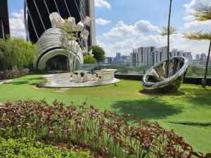 a park with a sculpture in front of a building at Arte Mont Kiara by iLuxHome in Kuala Lumpur