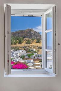 una finestra aperta con vista sulla città di Peni sol Superior Studios Lindos a Líndos