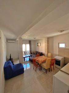 un soggiorno con tavolo e divano blu di Rajovic Apartments a Tivat