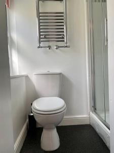 a bathroom with a white toilet and a mirror at Courtyard Cottage in Knaresborough