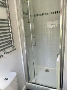 un bagno bianco con doccia e WC di Courtyard Cottage a Knaresborough