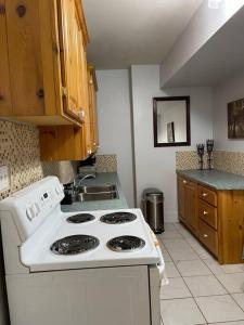 uma cozinha com um fogão branco e um lavatório em My Cozy Apartment Cottage em Grande-Digue